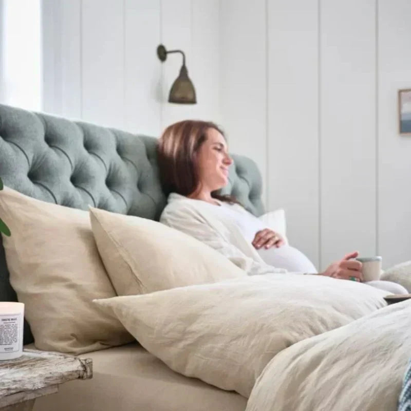 Pregnant lady drinking coffee in a woolroom bed