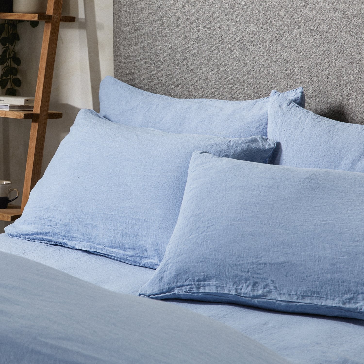 Four pillows on a dressed bed with the Mariana Linen Blend Pillow Cases in Cornflower.