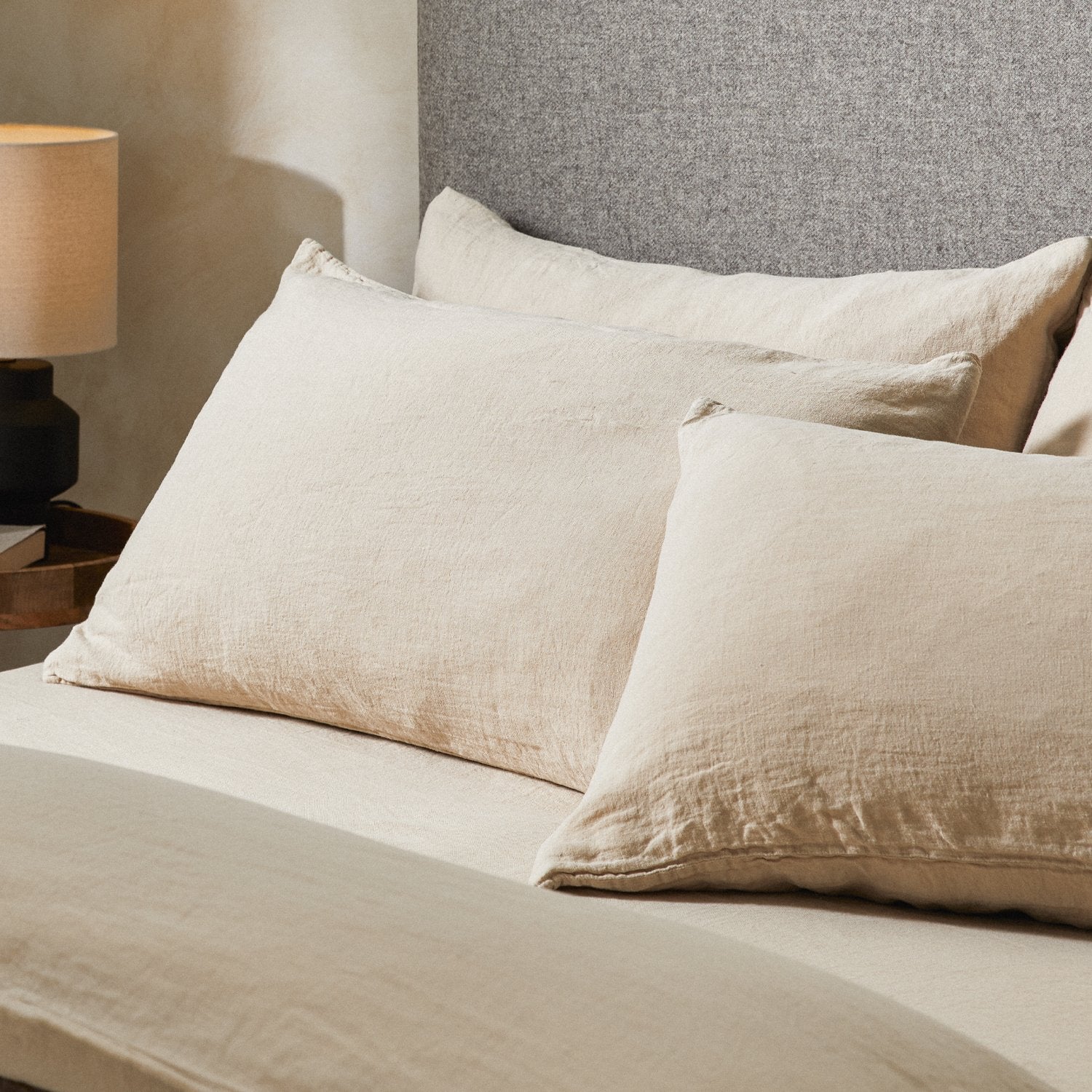 Four pillows on a dressed bed with the Mariana Linen Blend Pillow Cases in Sand.