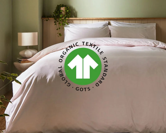Bed with white bedding and a visible Global Organic Textile Standard logo in a bedroom setting.